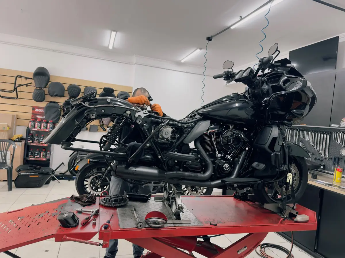 Bancos para Harley-Davidson expostos na Rooter's Garage, com uma Road Glide no elevador da oficina